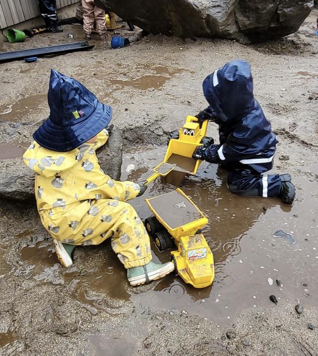 to barn leker med biler i sølevannet