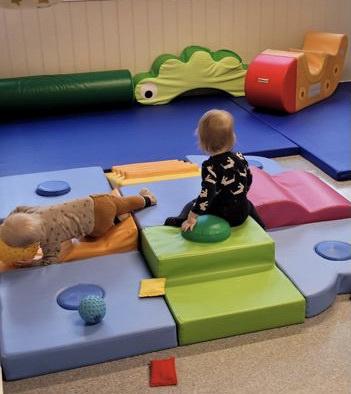 to små barn leker på mange puter og madrasser