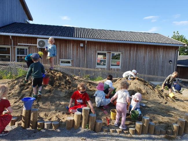 mange barn leker i stor sanddunge