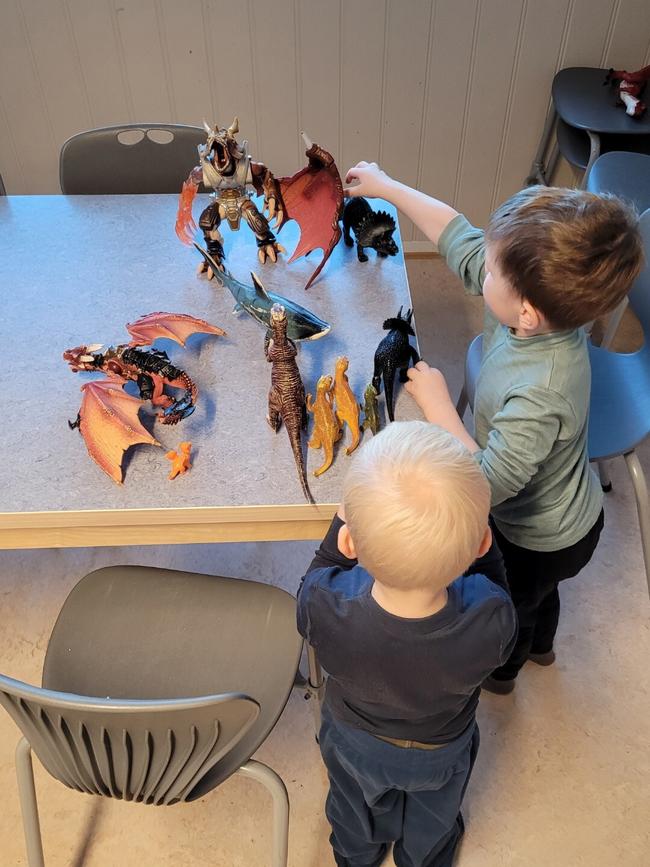 to barn leker med dinosaurfigurer